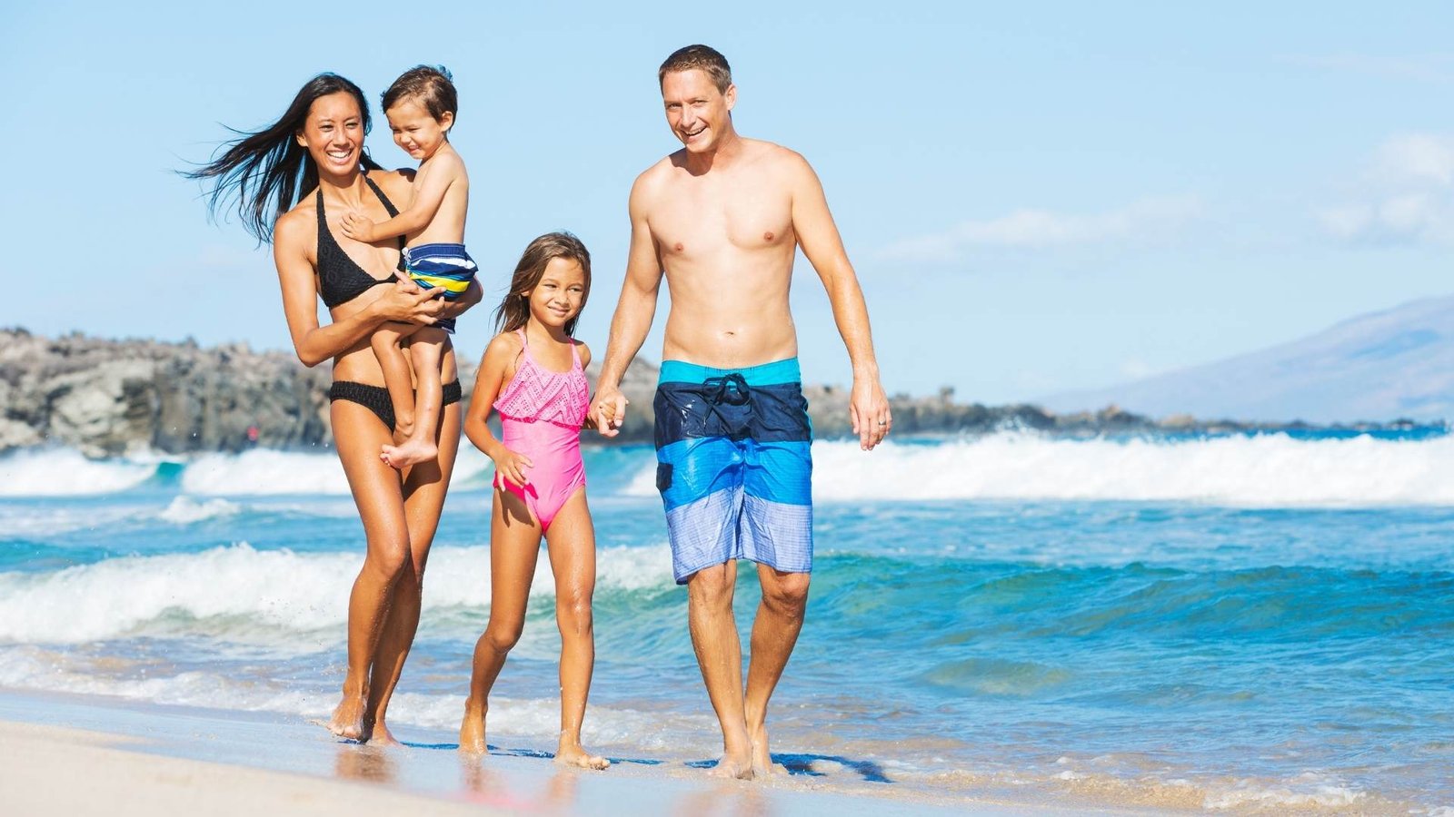 image showing family on beach nhs travel vaccines