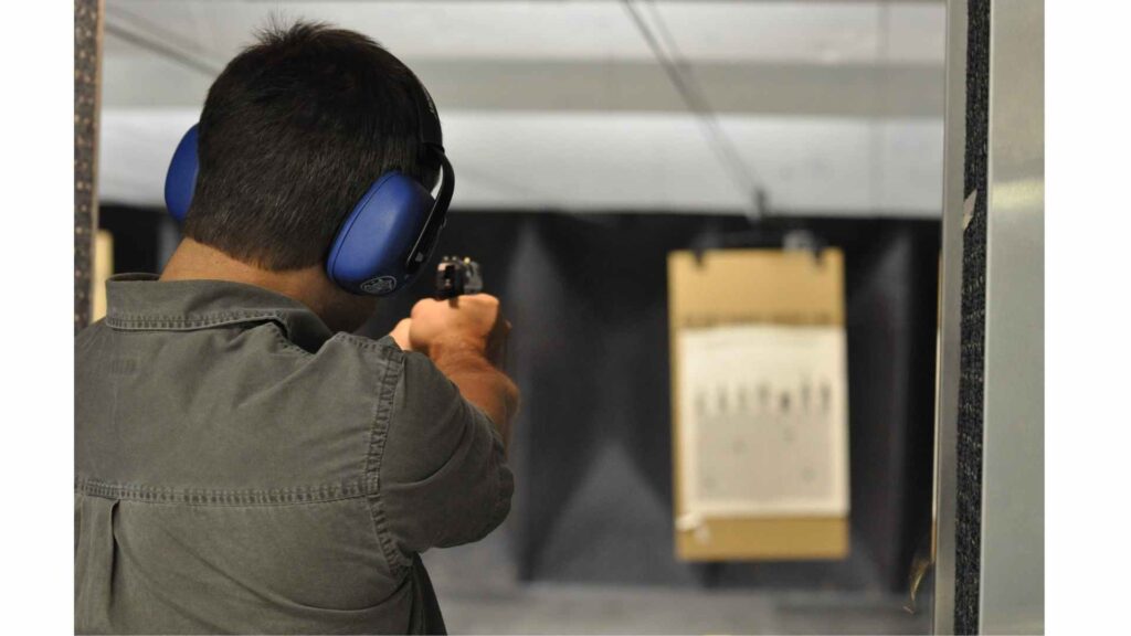 Man taking aim with a gun, as an analogy of the process of phlebotomy aiming for veins 