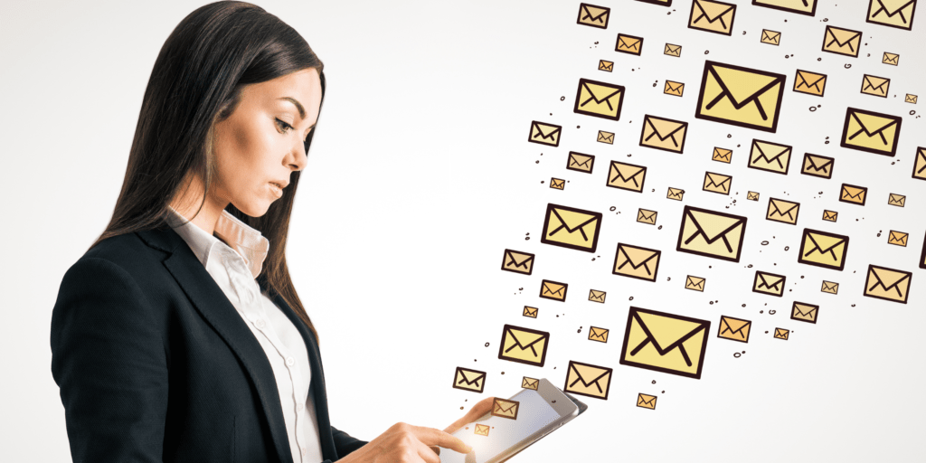 A woman holds an ipad with email icons flying from it showing the need for data protection training to avoid GDPR issues when sending mass mail outs