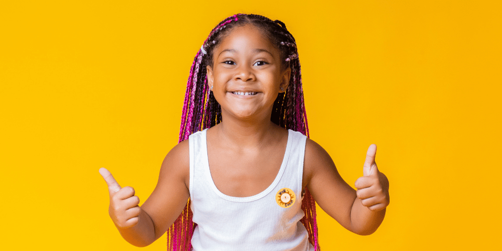 Image of a girl holding her thumbs up with a sticker saying well done - injecting children